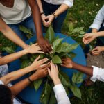 group-people-holding-hands-around-table-with-blue-tablecloth-1-696×696